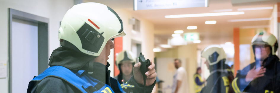 Männer in Schutzausrüstung bei einer Übung Zur Gefahrenabwehr