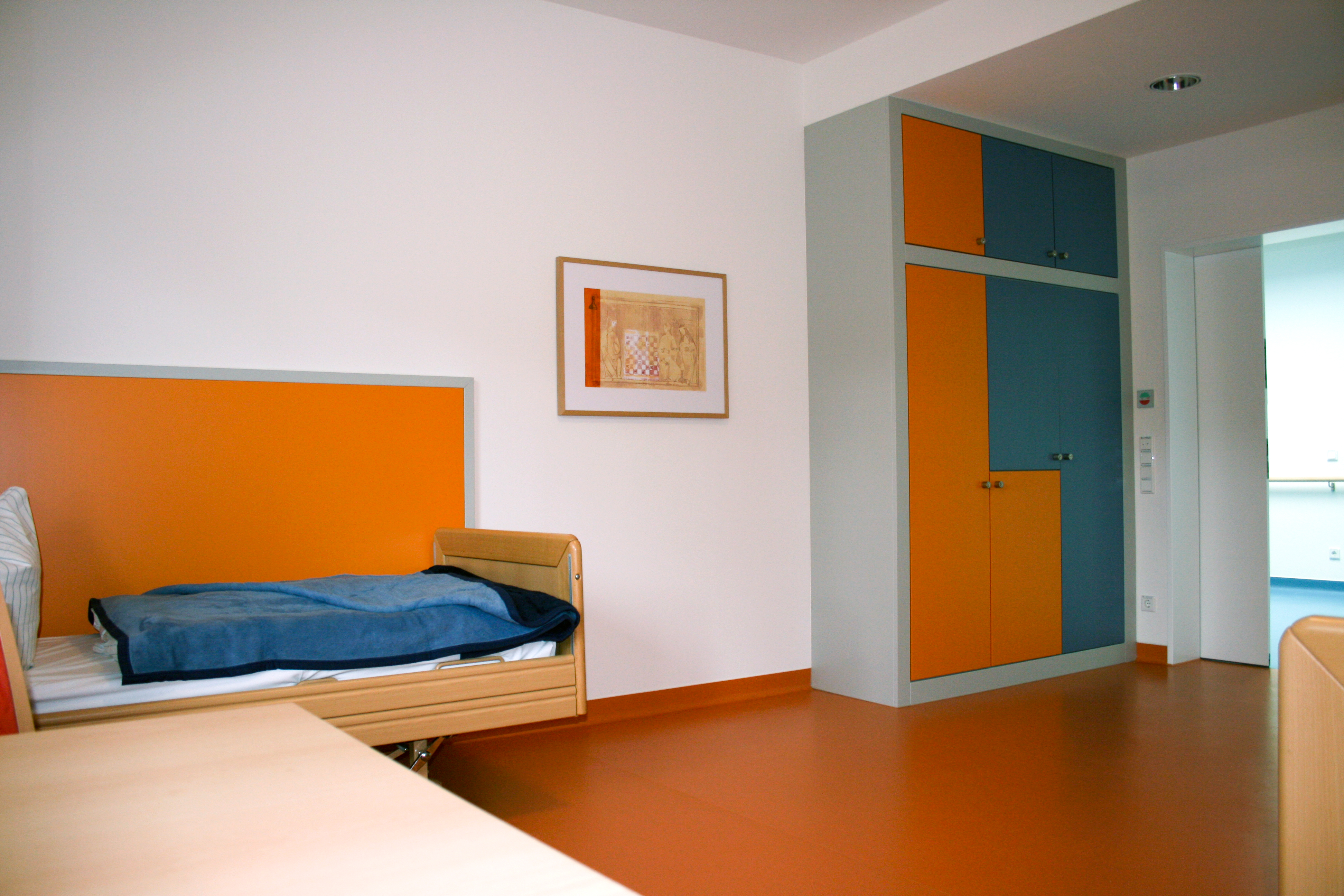 Patientenzimmer mit Bett, Tisch, Schrank