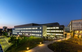 Das Charles-Tanford-Proteinzentrum in Halle ist ein moderner Forschungsbau, der auf dem Foto in der Dämmerung gezeigt wird. Im Gebäude brennen noch viele Lichter aus den Forschungslaboren.