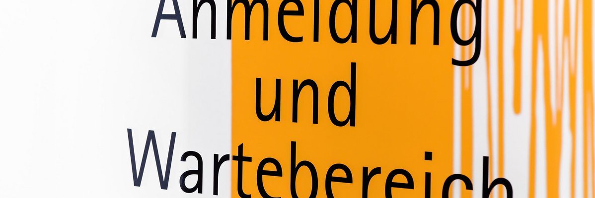 Schild mit Aufschrift Anmeldung und Wartebereich