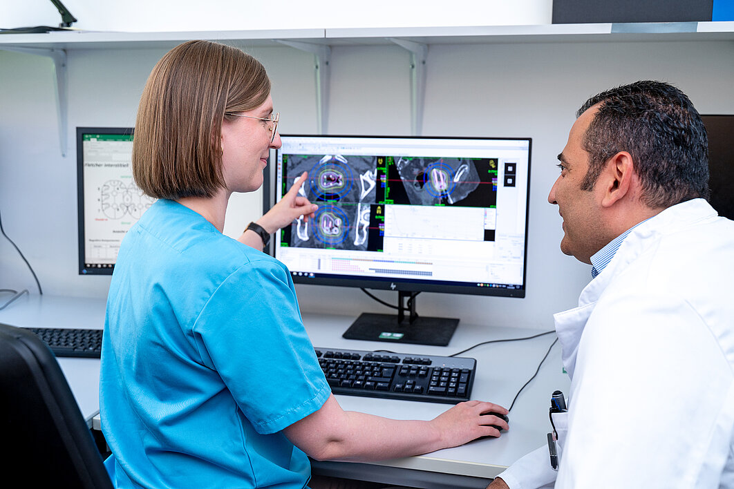 Medizinphysikerin stellt dem Arzt einen individuellen Bestrahlungsplan vor