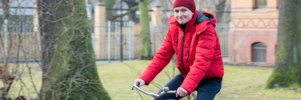 Fahrradfahrer in roter Kleidung im Park