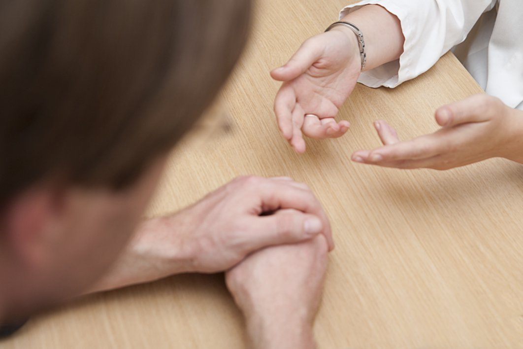 gestikulierende Hände auf dem Tisch als Sinnbild für therapeutisches Gespräch