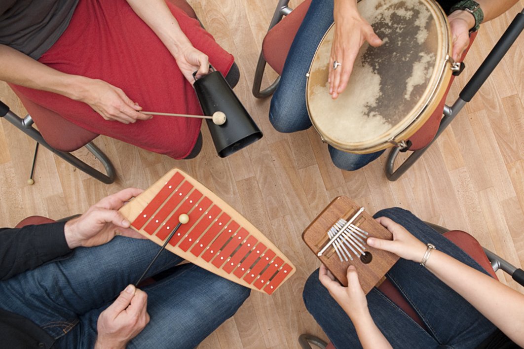 Vier Menschen im Kreis mit Klanginstrumenten