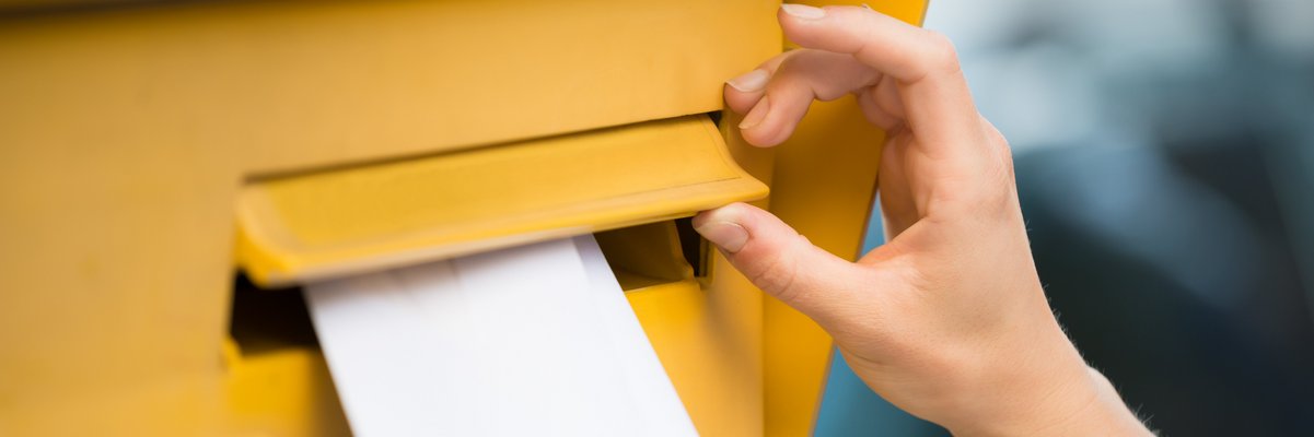 Ein Brief wird in einen Briefkasten gesteckt