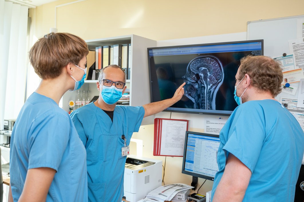 Medizinisches Personal wertet am Monitor die Röntgenaufnahme eines Kopfes aus