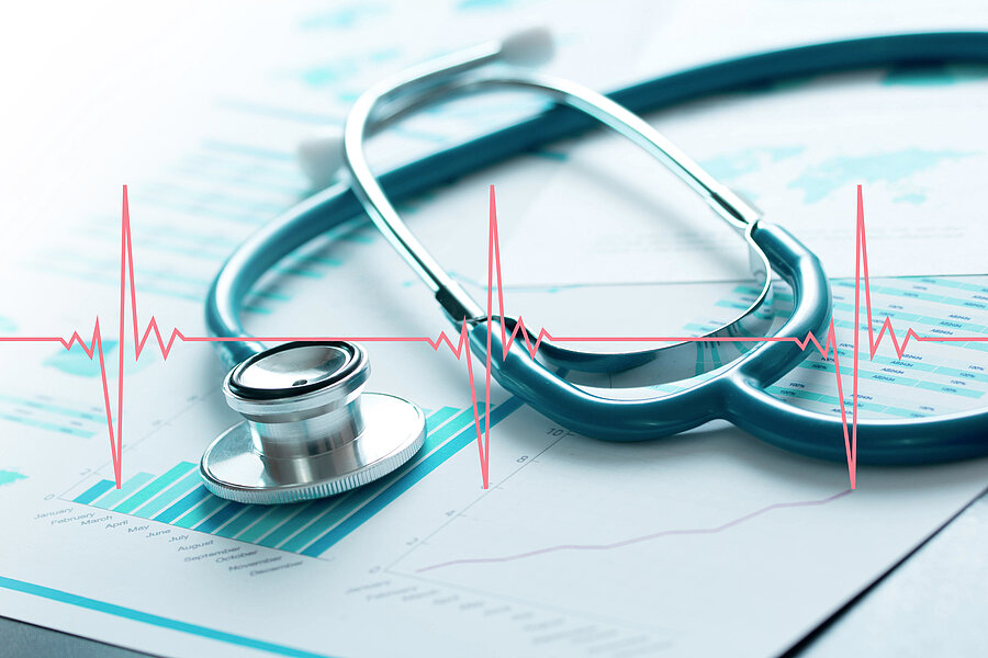 Ein Stethoskop liegt auf einer Fläche. Darüber verläuft ist ein Kardiogramm.  Ein Stethoskop liegt auf einer Fläche. Darüber verläuft ist ein Kardiogramm.