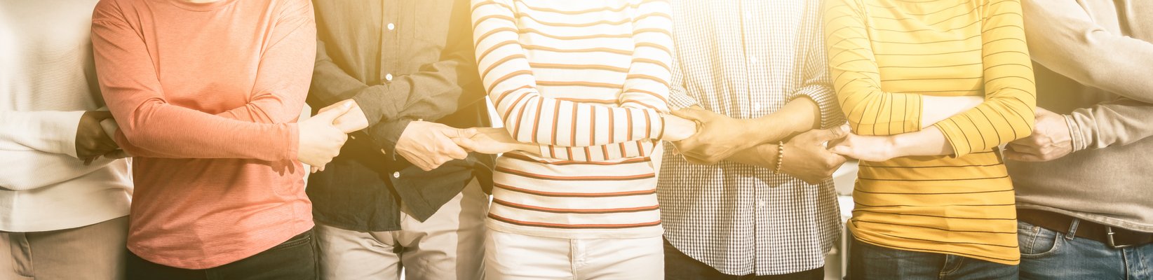 Menchen halten sich an den Händen als Symbol für Teamwork