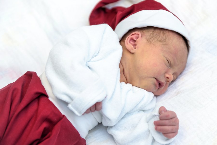 Neugeborenes Baby mit Weihnachtsmannmütze und roter Hose.  Neugeborenes Baby mit Weihnachtsmannmütze und roter Hose.