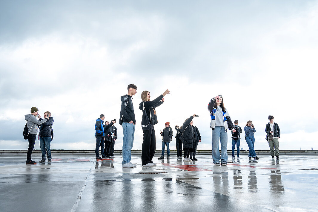 Schüler:innen fotografieren sich auf dem Hubschrauberlandeplatz des Universitätsklinikums.