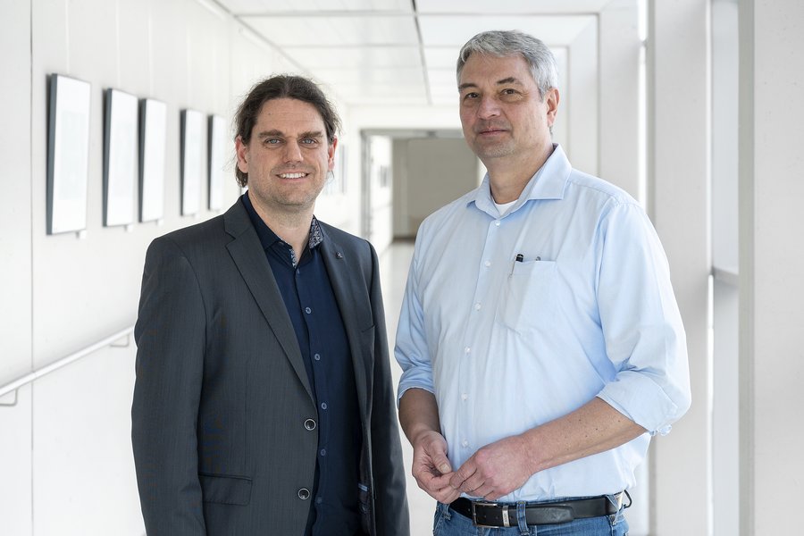 Dr. Tobias Esser und Prof. Dr. Martin Kaiser (v. l.) stehen in einem Gang im Hauptgebäude des Universitätsklinikums Halle (Saale).  Dr. Tobias Esser und Prof. Dr. Martin Kaiser (v. l.) stehen in einem Gang im Hauptgebäude des Universitätsklinikums Halle (Saale).