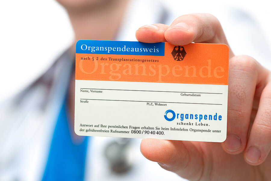 Detailaufnahme: Eine Hand hält einen Organspendeausweis in die Kamera.  Detailaufnahme: Eine Hand hält einen Organspendeausweis in die Kamera.