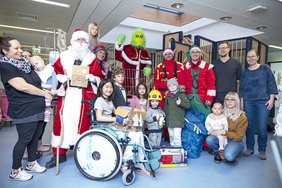 Gruppenbild der Mitarbeiter der Feuerwehr mit den Kindern und weiteren Beteiligten auf Station.