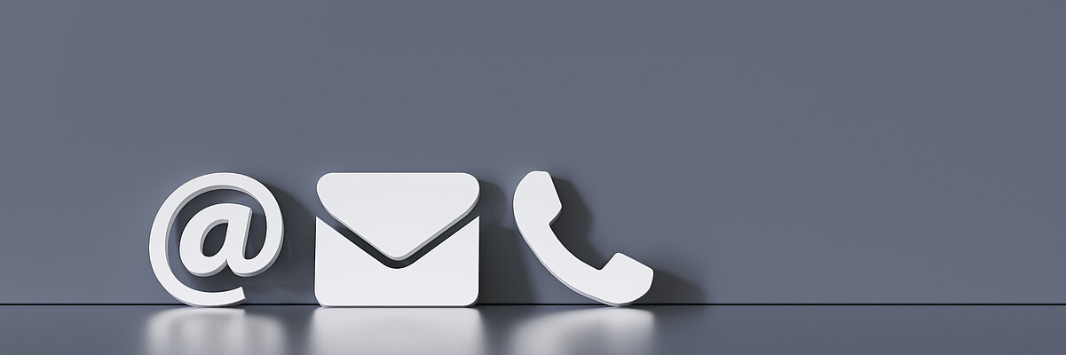 @-Zeichen, Briefumschlag und Telefonhörer in weiß auf grauen Grund als Symbol für Kontakt