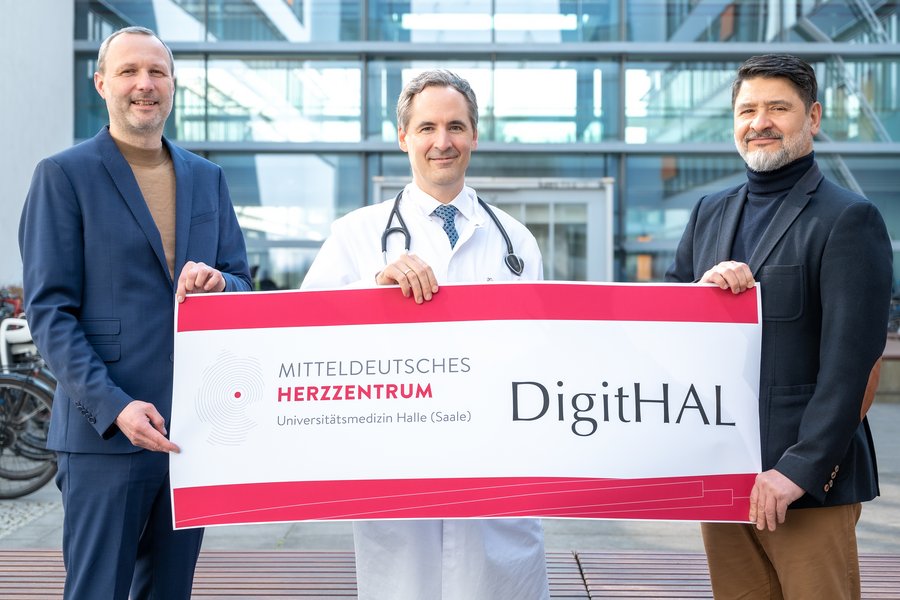 Drei Männer halten ein Schild in die Kamera, das den Projektnamen "DigitHAL" trägt.  Drei Männer halten ein Schild in die Kamera, das den Projektnamen "DigitHAL" trägt.