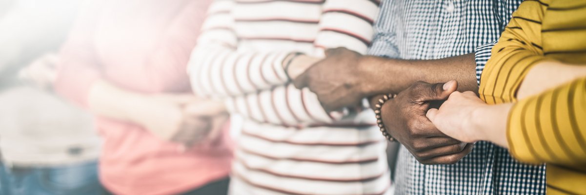 Menschen bilden eine Reihe, verschränken ihre Arme und halten einander fest