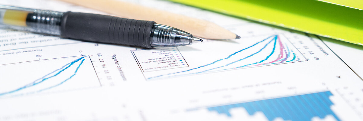 Mappe, Stift und Auswertungsunterlagen auf einem Tisch