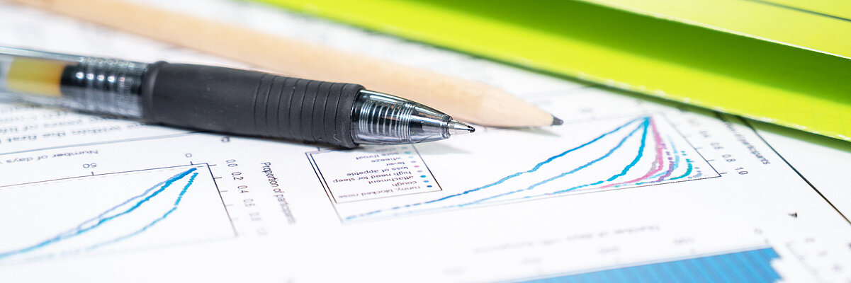 Mappe, Stift und Auswertungsunterlagen auf einem Tisch
