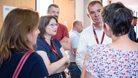 Dr. Katja Pähle und Marco Tullner sprechen mit einer Frau, die von hinten zu sehen ist. Links ist von schräg hinten Prof. Dr. Heike Kielstein zu sehen, im Hintergrund Alexander Beblacz.