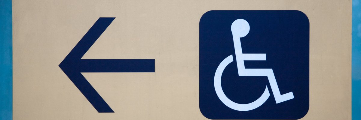 Schild mit Pfeil und Symbol für Rollstuhlfahrer