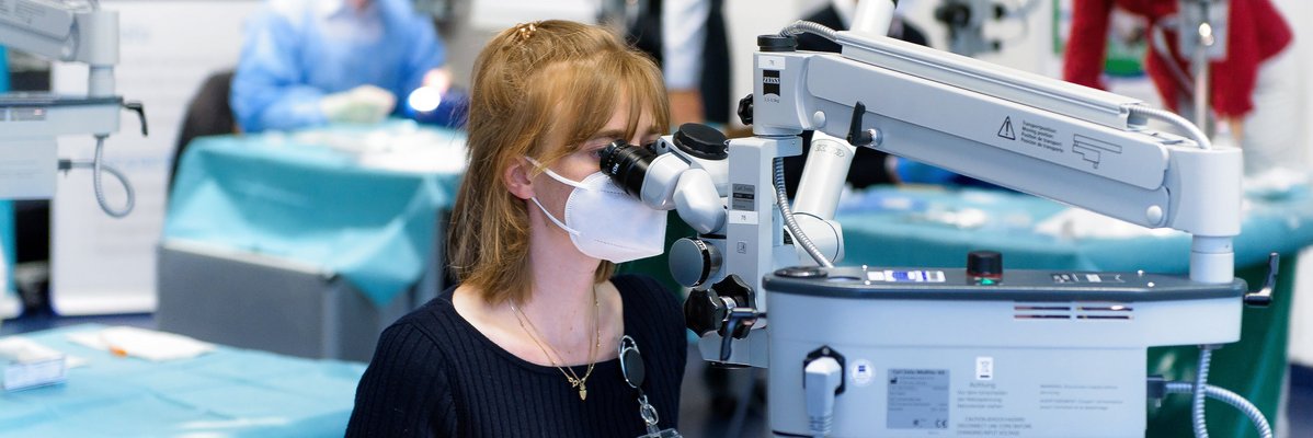 Frau an einem speziellem Mikroskop der Augenmedizin