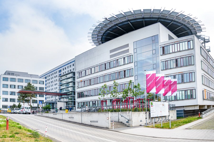 Hauptgebäude des Universitätsklinikums Halle (Saale). Davor wehen Fahnen mit dem Logo.  Hauptgebäude des Universitätsklinikums Halle (Saale). Davor wehen Fahnen mit dem Logo.