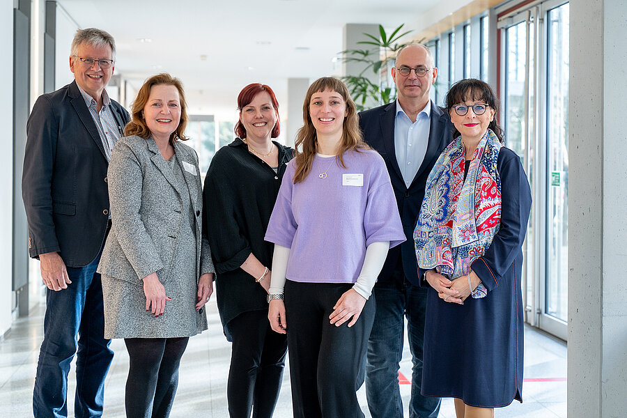 Gruppenbild: Vier Organisator:innen des Geriatrietags 2026 der Universitätsmedizin Halle, die Dekanin der Medizinischen Fakultät der MLU und die Keynote-Speakerin stehen in einem Gang. Gruppenbild: Vier Organisator:innen des Geriatrietags 2026 der Universitätsmedizin Halle, die Dekanin der Medizinischen Fakultät der MLU und die Keynote-Speakerin stehen in einem Gang.