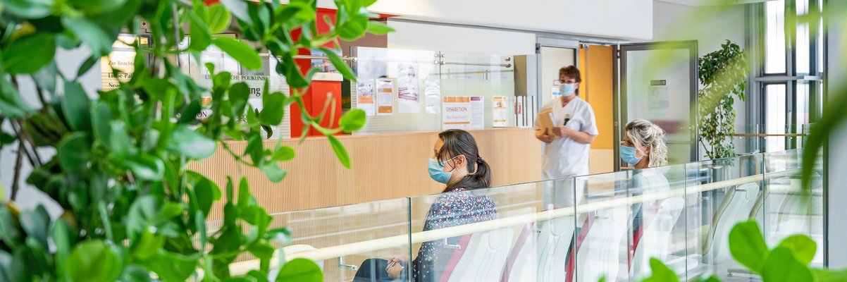 Wartende auf den Sitzen am Tresen der Urologie