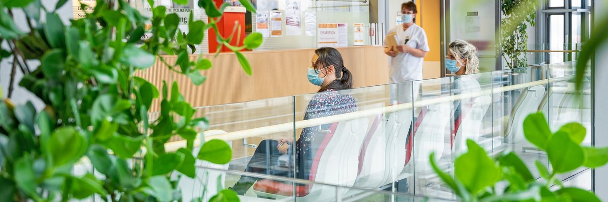 Wartende auf den Sitzen am Tresen der Urologie