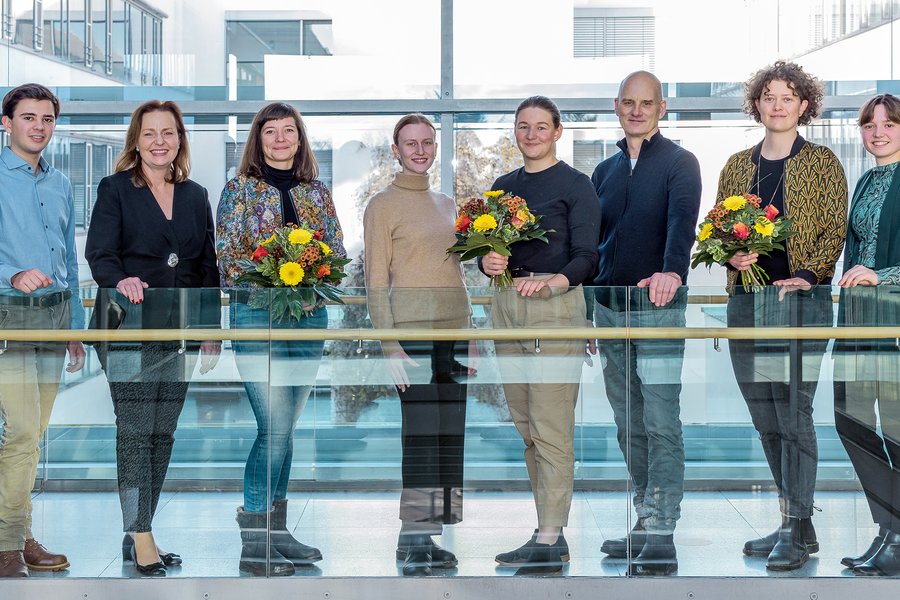 Acht Personen stehen in einem lichtdurchfluteten Korridor. Drei Personen halten einen Blumenstrauß. Sie ist die Lehrpreisträgerinnen aus der Hebammenwissenschaft.   Acht Personen stehen in einem lichtdurchfluteten Korridor. Drei Personen halten einen Blumenstrauß. Sie ist die Lehrpreisträgerinnen aus der Hebammenwissenschaft. 