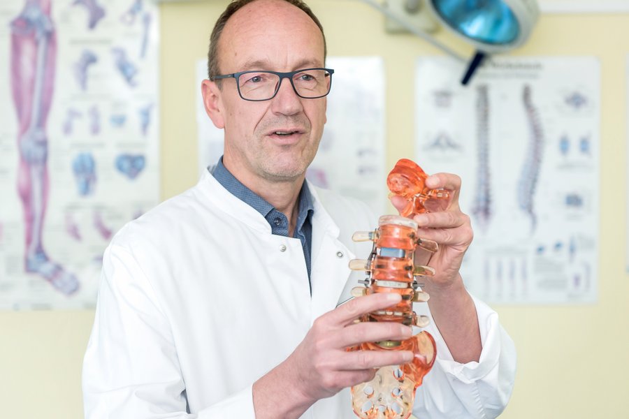 Prof. Dr. Karl-Stefan Delank hält ein Wirbelsäulen-Modell in den Händen.  Prof. Dr. Karl-Stefan Delank hält ein Wirbelsäulen-Modell in den Händen.