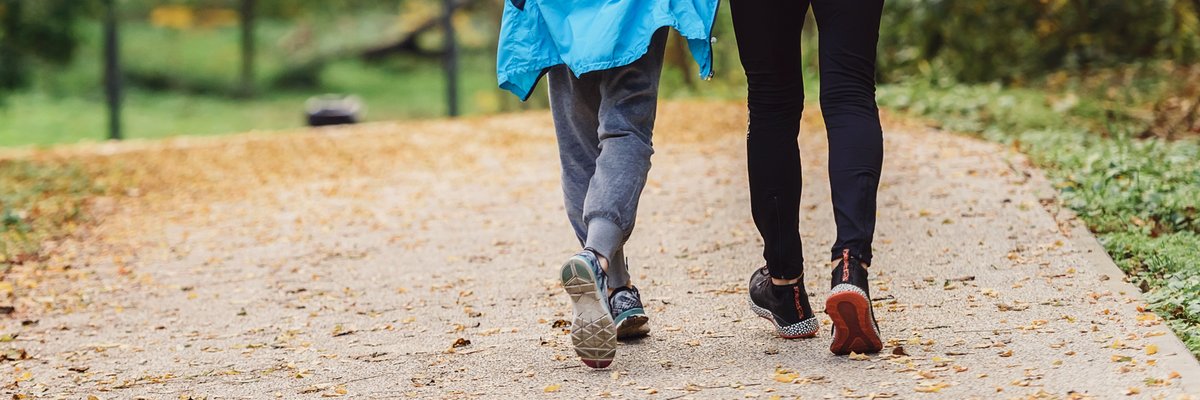 Ein Mann und eine Frau laufen in Sportsachen durch den Wald