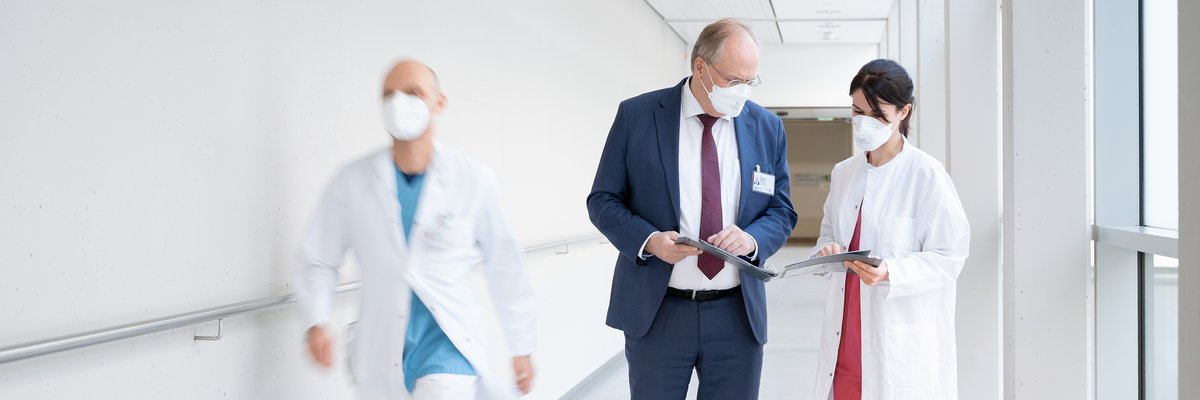Ärztlicher Direktor spricht auf einem Gang mit einer Ärztin