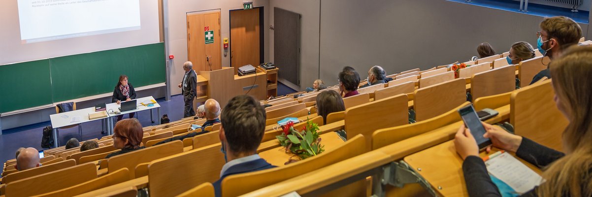 Menschen sitzen im Hörsaal bei einer Veranstaltung